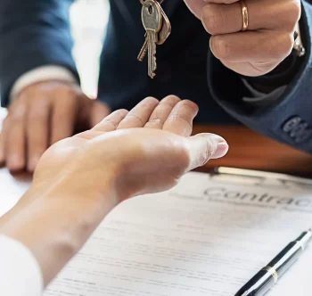 close up on hands, a real estate agent handing keys to a new owner